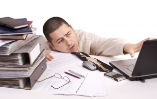 Frazzled businessman with his head on his desk at work