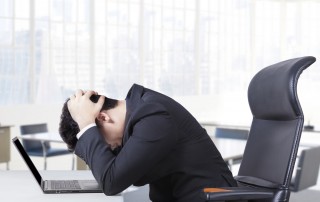 Man hunched over his desk at work