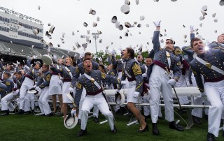 Image of West Point graduates throwing their caps in the air