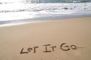 Words "Let it Go" written in sand