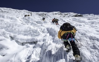 Climbers scaling a vertical face of Ice in Nepal