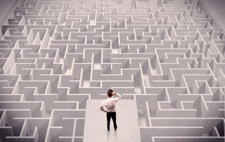 businessman staring at a complex maze