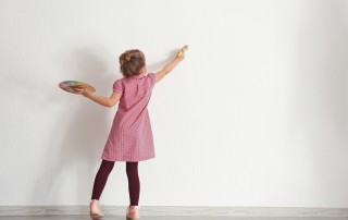 Image of a girl just starting to paint a blank wall