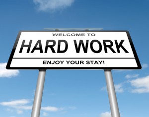 Road sign that says: Welcome to Hard Work-Enjoy Your Stay