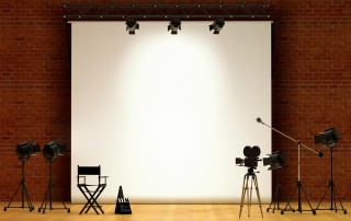 empty stage with chair, screen, and camera