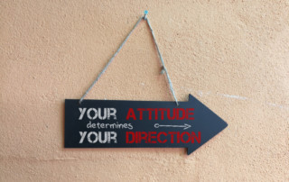 Sign in the shape of an arrow with the words: "Your attitude determines your direction"