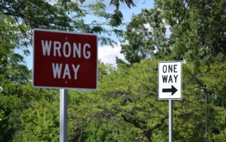 Road signs: one says Wrong Way and the other says One Way